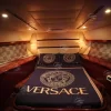 Cozy bedroom with Versace bedding inside Al Shali yacht