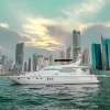 Luxury yacht Mayyas sailing at sunset with Dubai skyscrapers
